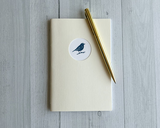 Signature Mini handbound journal in Moonlight ivory linen-textured cardstock with circular logo window.